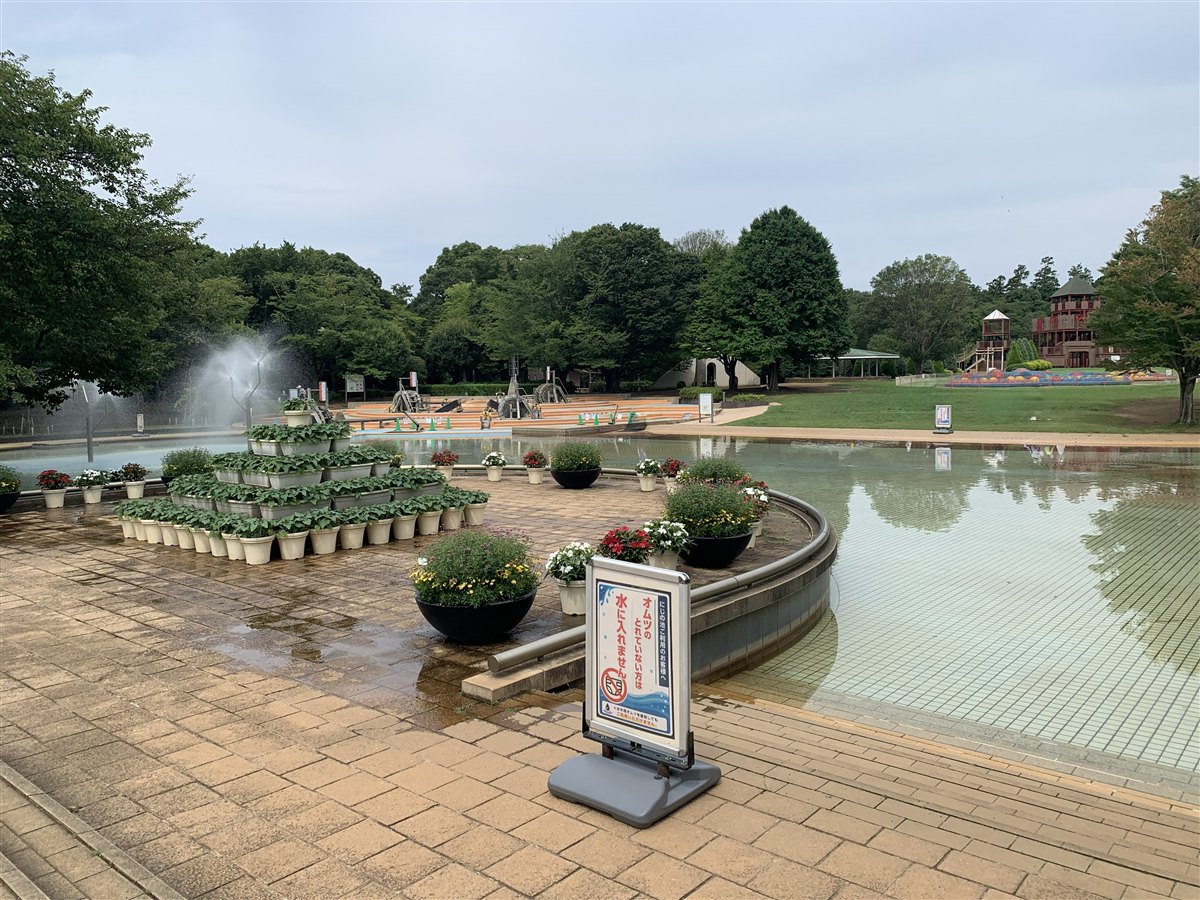 ふなばしアンデルセン公園のにじの池。手前に「オムツのとれていない方は水に入れません」の看板、奥に噴水と水遊びエリアが広がる