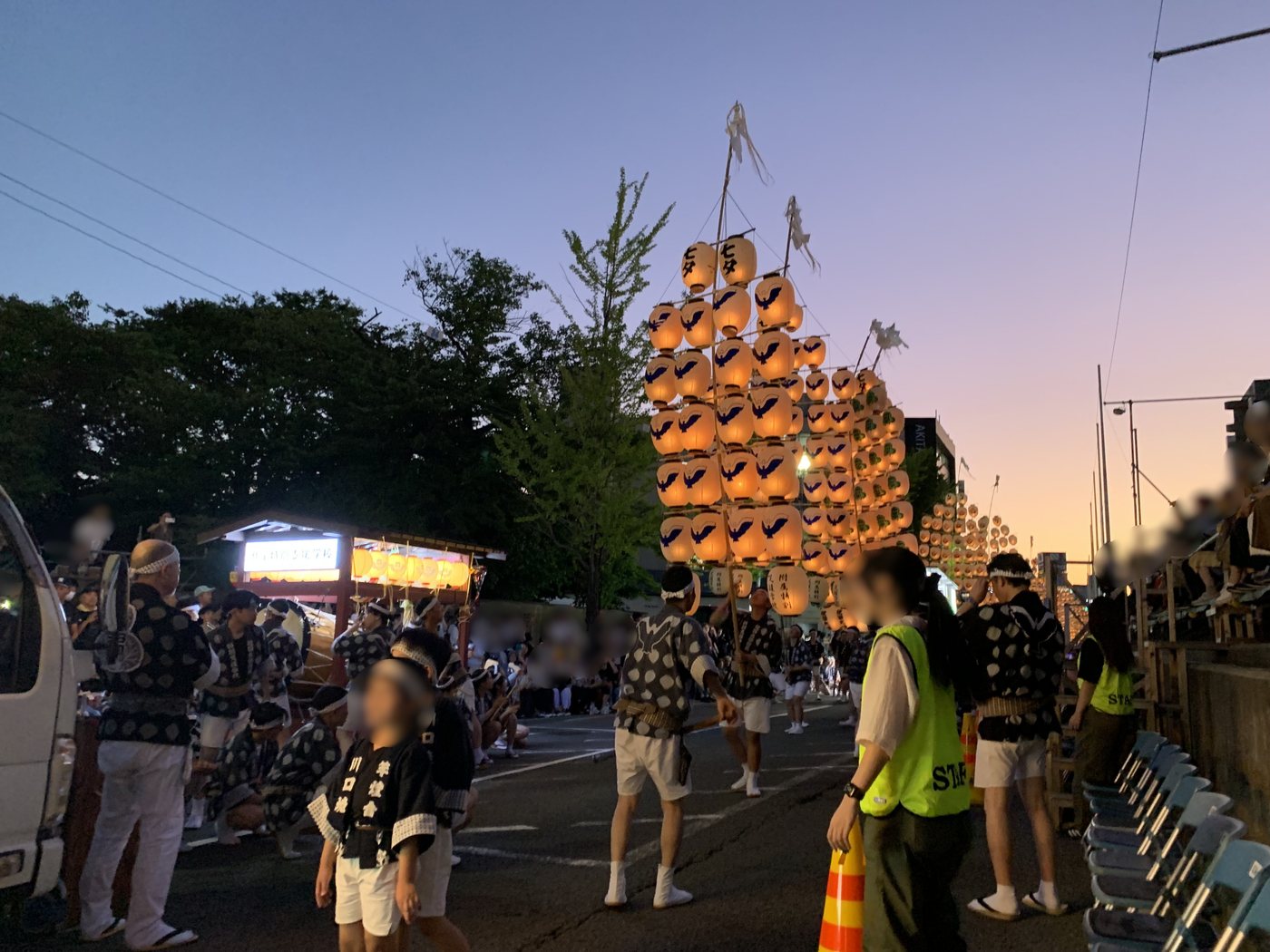 夕暮れの空を背に立ち上がる秋田竿燈まつりの竿燈