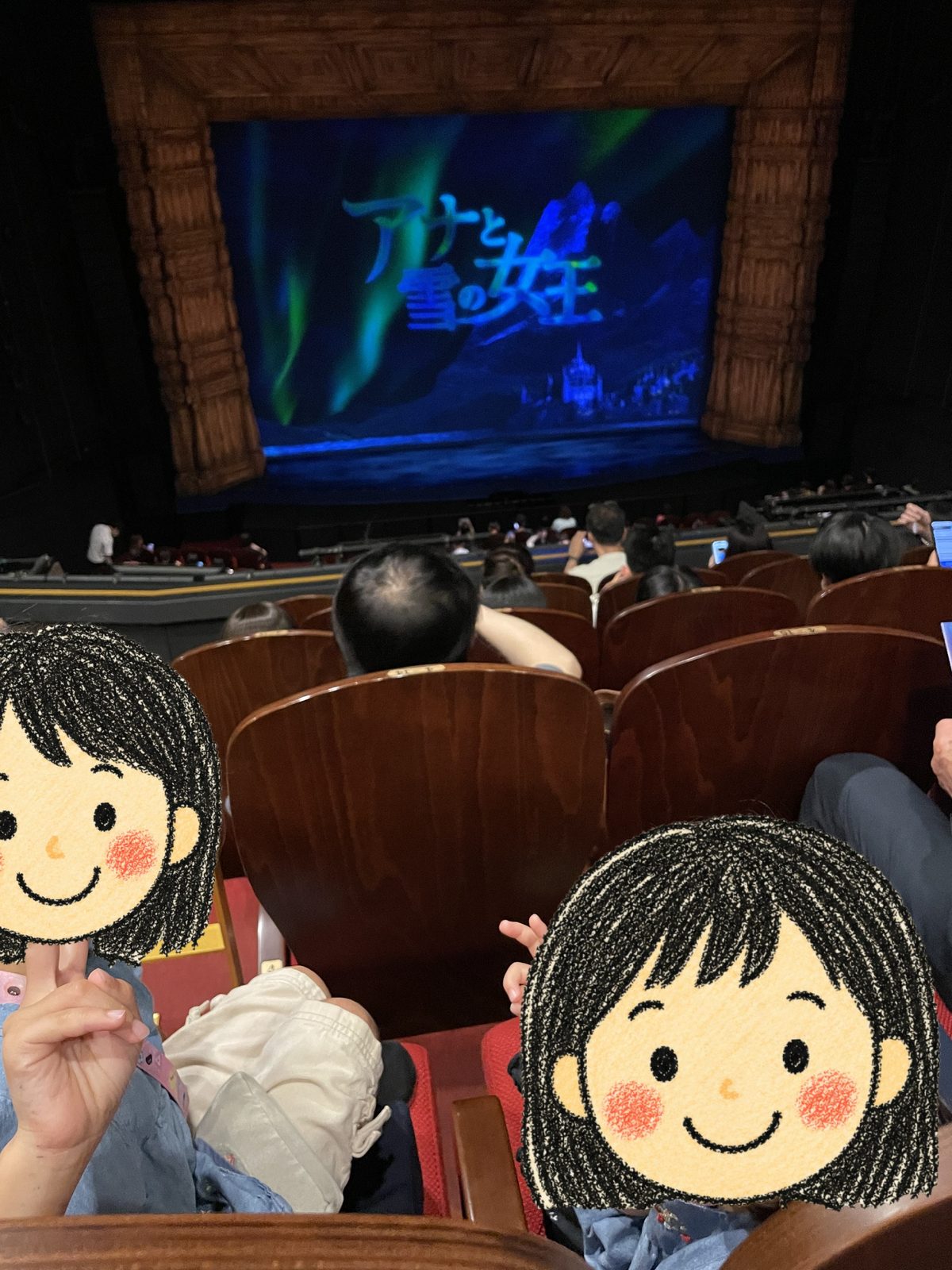 開演前の客席から見た舞台。緞帳に「アナと雪の女王」のタイトルが映っている