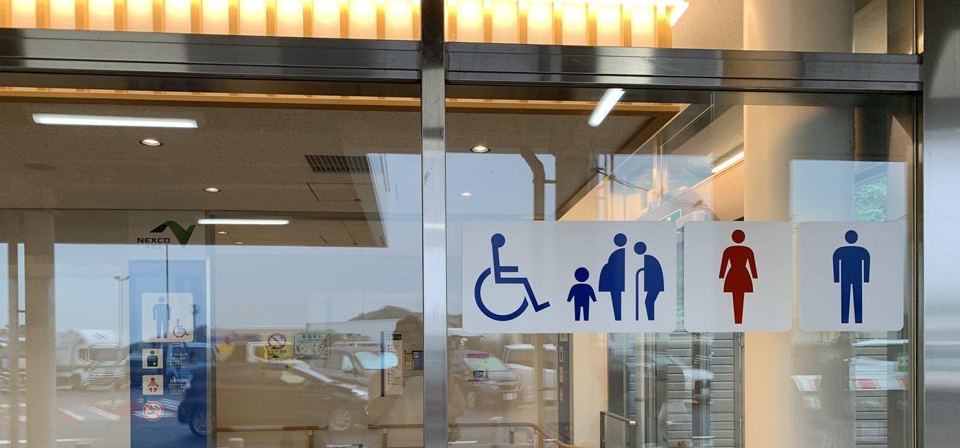 国見SAのトイレ入口。多目的トイレと子ども連れ用の案内サイン