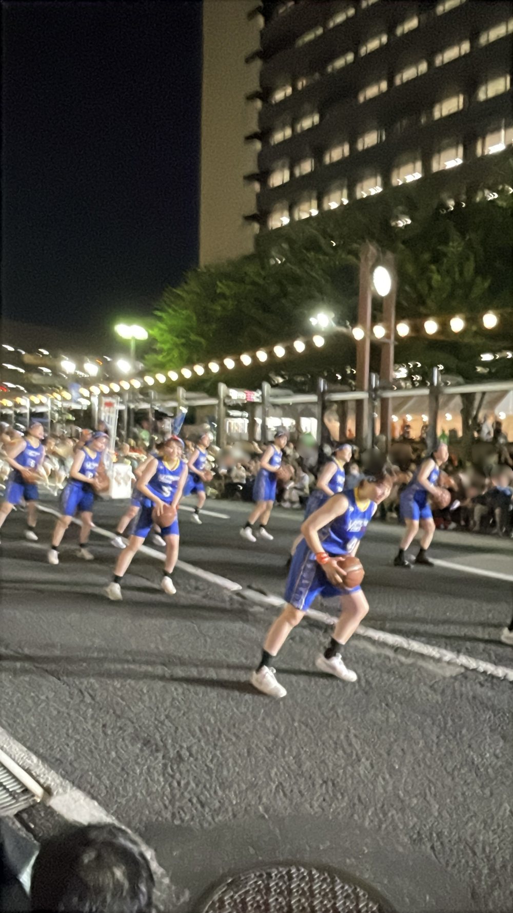 バスケットボールを持って踊る女子バスケチーム。伝統衣装以外の参加も多い
