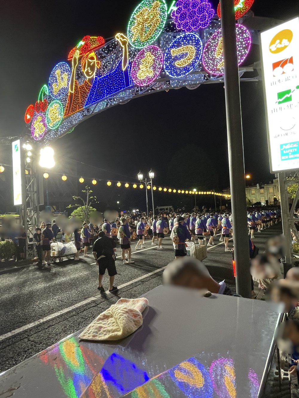 祭りの終盤。提灯の下に色とりどりの花笠が並ぶ